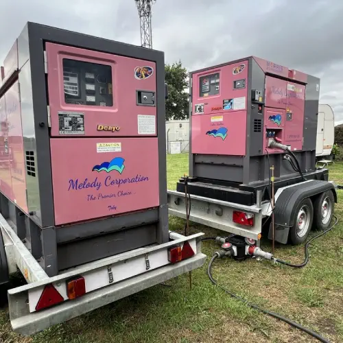 Two large, portable generator hire melody corporation units mounted on trailers at an outdoor location.