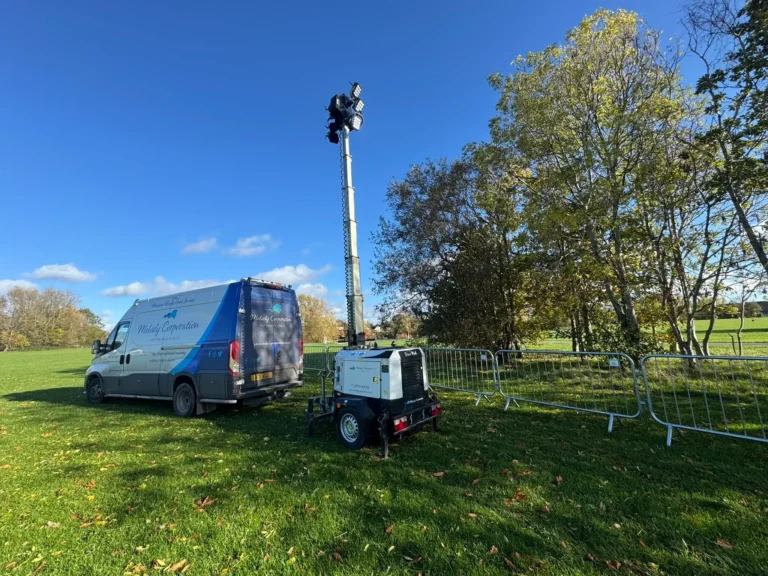 Portable lighting generator next to a mobile light tower in a park